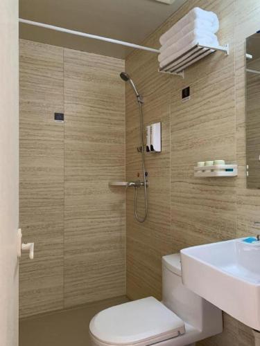 a bathroom with a shower and a toilet and a sink at PAI Hotels Shijiazhuang Railway Station West Square in Shijiazhuang