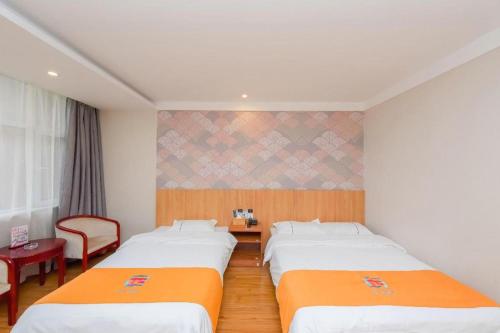 a hotel room with two beds and a chair at PAI Hotels Shijiazhuang Railway Station West Square in Shijiazhuang