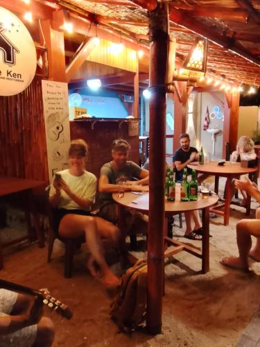 a group of people sitting at tables in a restaurant at Three Ken Homestay & Cafe in Manado