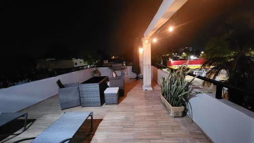 a balcony with couches and tables on a roof at night at Casa Rafaelita in Mérida