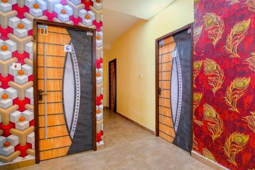 a room with two doors with a surfboard on the wall at Super Hotel O Ashiyana Guest House in kolkata