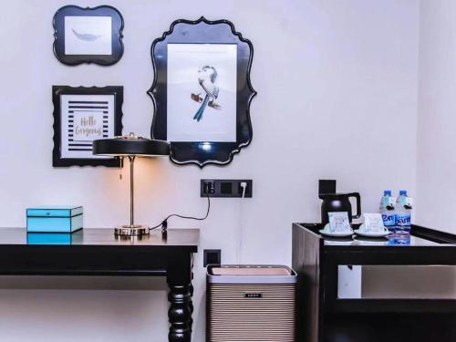 a desk with a lamp and a mirror on a wall at Xana Hotelle Wuxi Railway Station Zhongshan Road in Wuxi