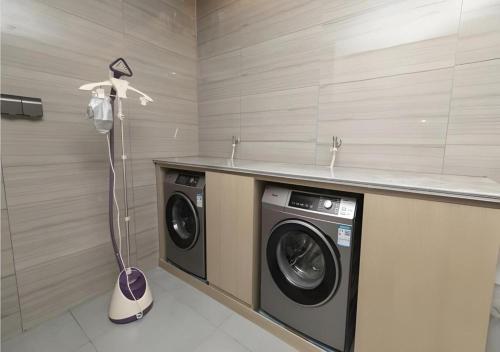 a laundry room with a washer and dryer in it at Echarm Hotel Hefei West Qilitang Metro Station in Hefei