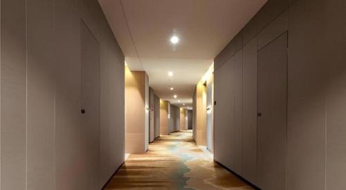 a hallway with a long corridor with water on the floor at E-Cheng Hotel Yangjiang Baili Plaza in Yangjiang