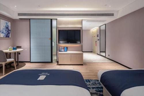 een kamer met twee bedden en een televisie bij Echarm Hotel Nanning Wuming in Wuming