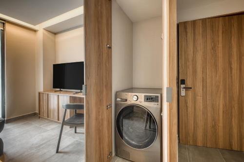 a washing machine in a room with a tv at Namóra by Lumina in Guadalajara