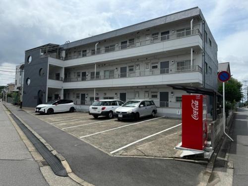 a building with cars parked in a parking lot at HYGGE HOUSE Tabibitonoie - Vacation STAY 33409v in Kashiwa