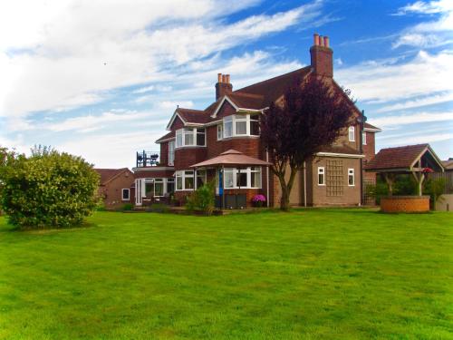 a large house with a green lawn in front of it at The Moorhead Bed & Breakfast in Wem