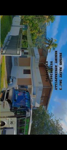 a tall building with cars parked in front of it at Pavans Rainy Days Home Stay in Athirappilly