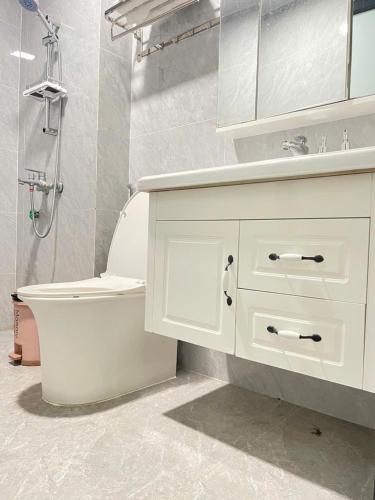 a white bathroom with a sink and a toilet at Snu Motel - Cao Bằng in Cao Bằng