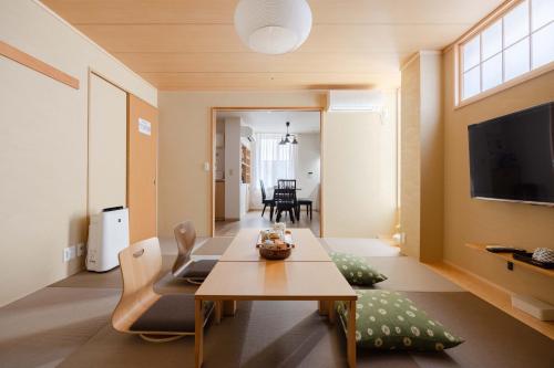 a living room with a table and a tv at Clover House in Tokyo