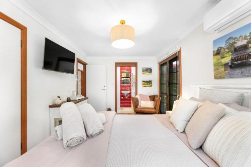 a bedroom with a white bed with white pillows at Central Tilba Overnight Retreat ! King Bed, Ensuite, Pet-Friendly in Central Tilba