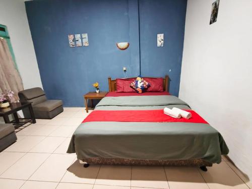 a bedroom with a large bed with red pillows at YUTAKA INN Araya Malang in Blimbing