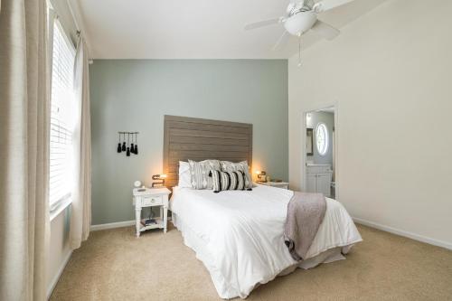 a white bedroom with a bed and a ceiling fan at Hotel Claytone Near Delhi Airport in New Delhi