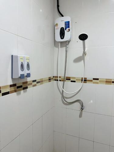 a bathroom with a shower with a phone on the wall at Rest And Relax Hostel in Ko Lanta