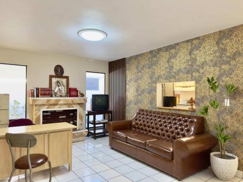 a living room with a leather couch and a fireplace at Casa Lomas Cozy 3 Bedroom 2 Bath House by Xolos Stadium in Tijuana