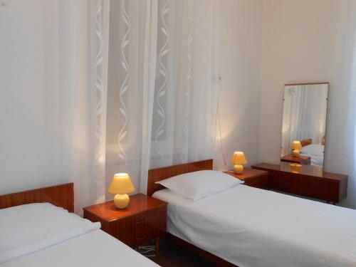 2 Betten in einem Zimmer mit 2 Lampen und einem Spiegel in der Unterkunft Apartment Petar in Lastovo