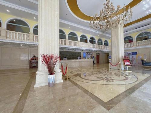 a large lobby with a chandelier in a building at Vienna Hotel Guangdong Shantou South Bus Station in Shantou