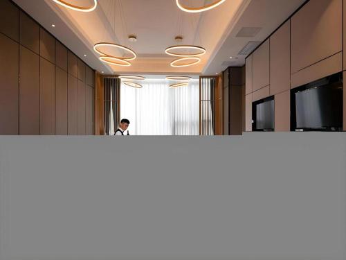 a man standing behind a counter in an office at Venus Royal Hotel Nanning East High-Speed Railway Station in Nanning