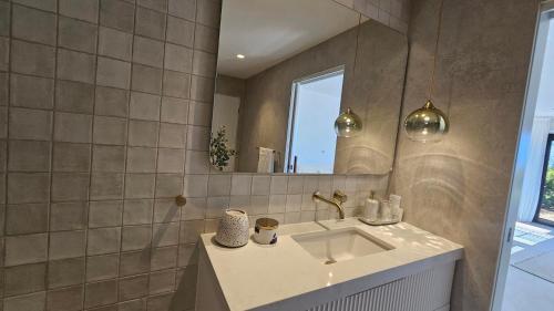 a bathroom with a sink and a mirror at Cielo Flaxton, Newly Renovated Luxury Accommodation with Ocean and Iconic Views in Flaxton