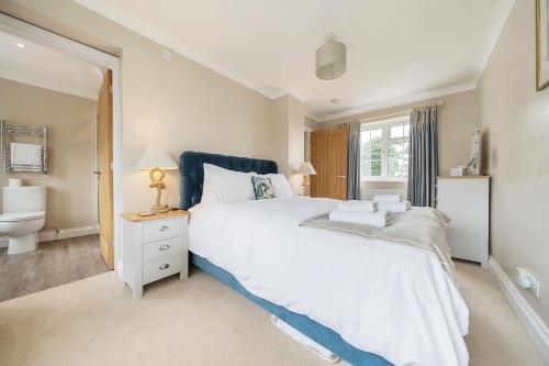 a bedroom with a large white bed and a toilet at Orchard House Docking in Docking