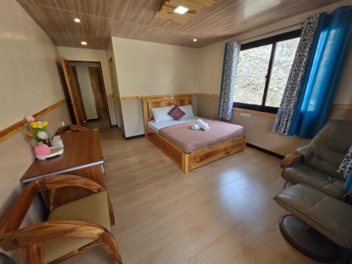 a room with a bed and a couch and a desk at Quarrybay Hometel Sagada in Sagada