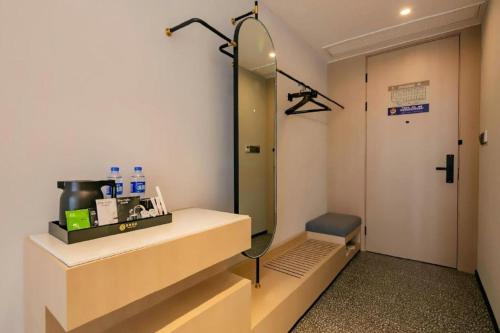 a bathroom with a sink and a mirror in a room at Airfeel Hotel in Ziyang