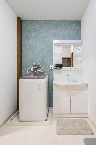 a white kitchen with a sink and a mirror at 勝清居 大阪獨棟車庫民宿 千日前線新深江站2分一線直達 難波日本橋 全新裝修3LDk in Osaka