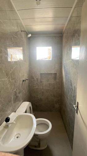a bathroom with a white toilet and a sink at Pousada Freitas in Feira de Santana