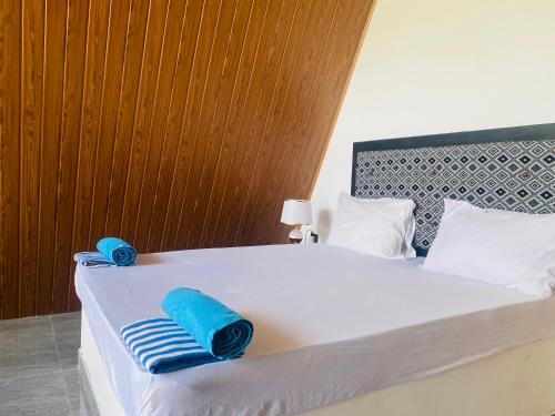 a bedroom with a bed with blue towels on it at Wonder of Udawalawe Cottage in Udawalawe