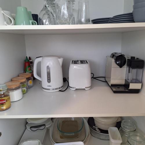a kitchen shelf with various appliances on it at Kings Beachside Escape spacious apartment centrally located in Caloundra