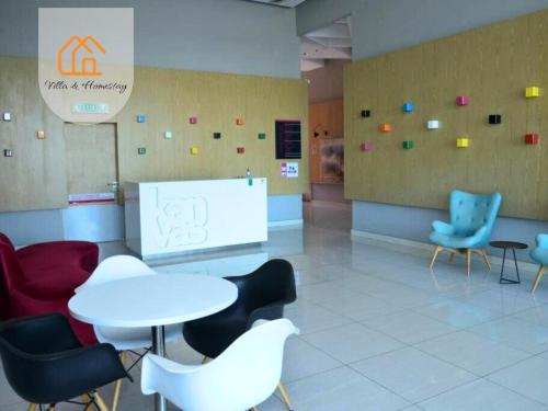 a waiting room with chairs and a table and a screen at Cozy Apartment for Two - KANVAS SOHO Cyberjaya in Cyberjaya