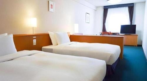 a hotel room with two beds and a television at Hotel Dream Gate Maihama in Chiba
