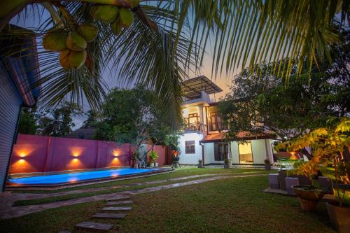 a house with a backyard with a swimming pool at Hikka Shells in Hikkaduwa