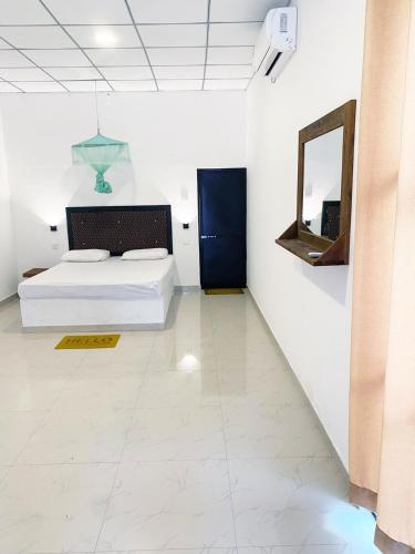 a bedroom with a bed and a mirror on the wall at Wonder of Udawalawe Cottage in Udawalawe
