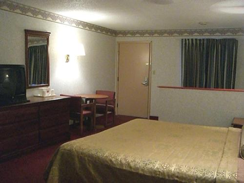 um quarto de hotel com uma cama, uma secretária e uma televisão em Red Carpet Inn Williamstown em Williamstown