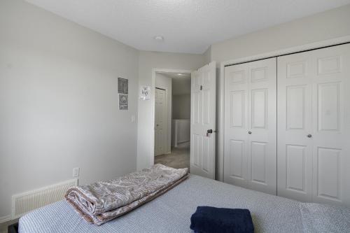 une chambre avec un lit avec une couverture dessus dans l'établissement EasyStay - Close to Edmonton Airport, Shared Washroom, à Edmonton