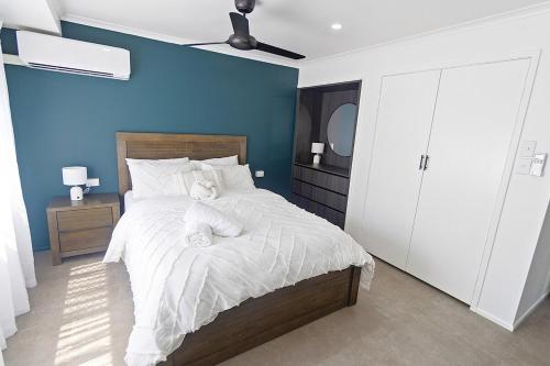 a bedroom with a bed with white sheets and a blue wall at Studio Three 