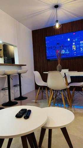 a room with two tables and chairs and a television at Departamento moderno a un lado de la feria in Pachuca de Soto