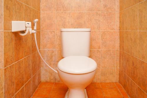 a bathroom with a toilet with a hose at Seaside Hotel in Gili Trawangan