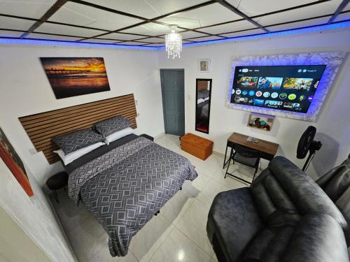 a bedroom with a bed and a flat screen tv at Sunrise Haven Holiday Apartments Barbados in Christ Church