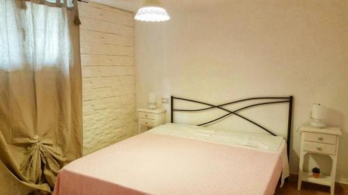 a bedroom with a white bed and a window at Il Fenicottero Rosa in Olbia