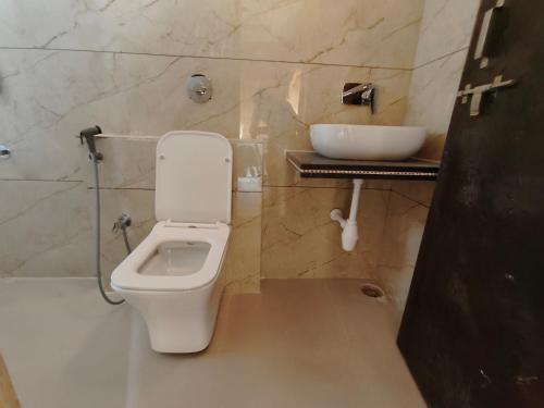 a bathroom with a white toilet and a sink at Hotel Golden Offbeat in Jaisalmer