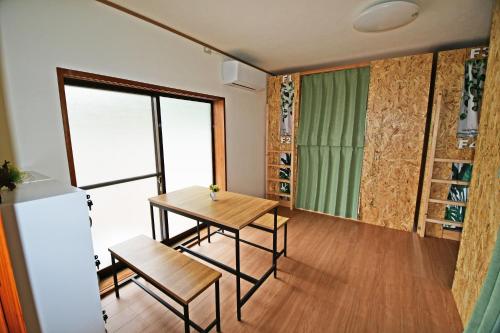 a small dining room with a table and a refrigerator at 鞆の浦ゲストハウス悠樂 Tomonoura Guest House You Raku in Fukuyama