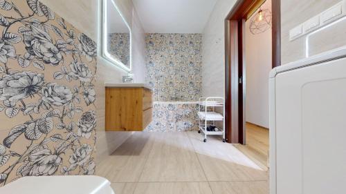 un pasillo con una pared con papel pintado con motivos florales en Koloseo apartman, en Bratislava