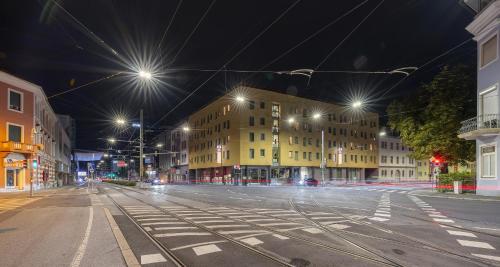 an empty city street at night with street lights at Best Western Plus Plaza Hotel Graz in Graz