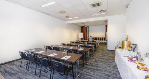 a row of tables and chairs in a room at Best Western Plus Plaza Hotel Graz in Graz