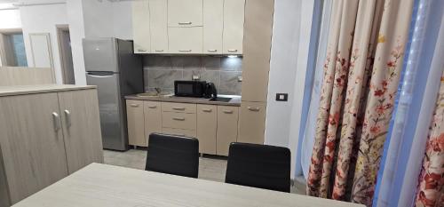 a kitchen with a table and two chairs and a microwave at Luxury Apartment in Alezzi Resort Piscina Interioara & Spa in Mamaia Nord