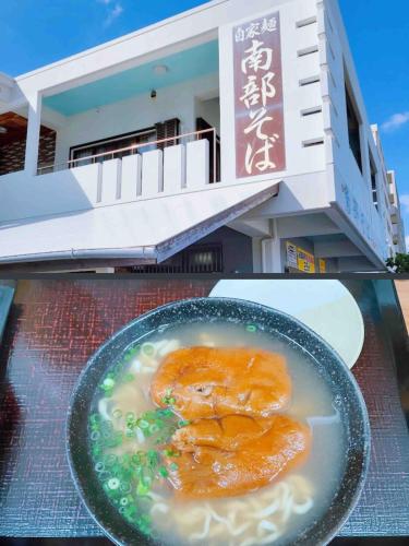 a bowl of food on a table in front of a building at ZZOKIAI藍魚 2 mins walk to the beach! Upscale villa area 15 mins from airport! Parking, dryer, baby cots are all available in Itoman