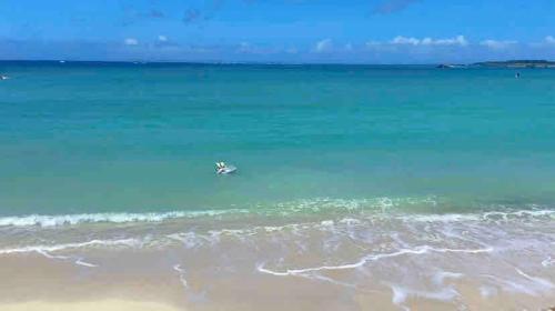 a boat in the water at the beach at ZZOKIAI藍魚 2 mins walk to the beach! Upscale villa area 15 mins from airport! Parking, dryer, baby cots are all available in Itoman